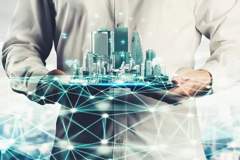Digital drawing of person holding city skyline with wifi symbols and lines indicating smart cities or data.